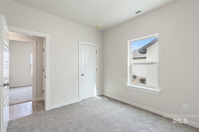 empty bedroom with light carpet white walls