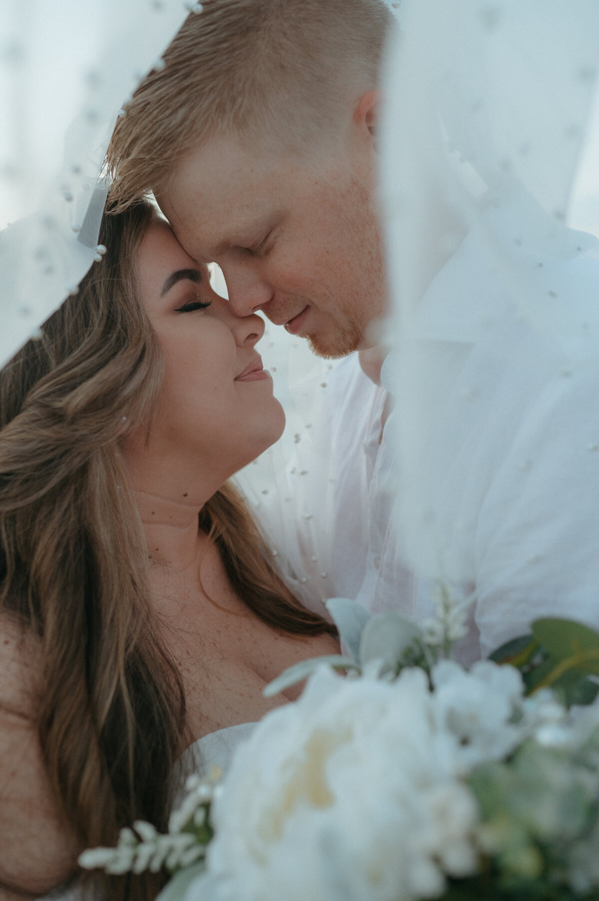 bride and groom under veil photos
