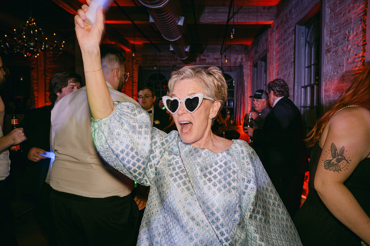 Modern reception moment with luxury guest dancing under vibrant flash party lighting