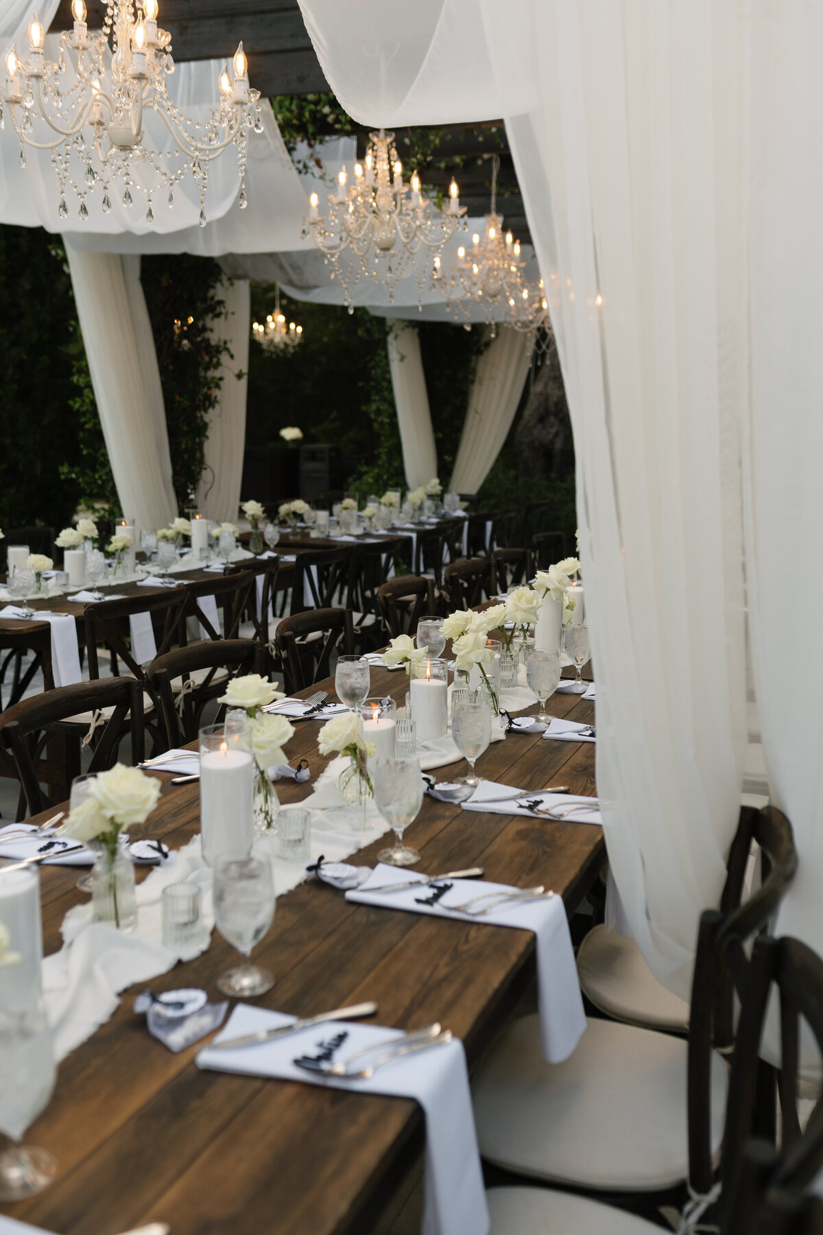 Elegant outdoor reception under chandeliers at La Casa Toscana wedding 
