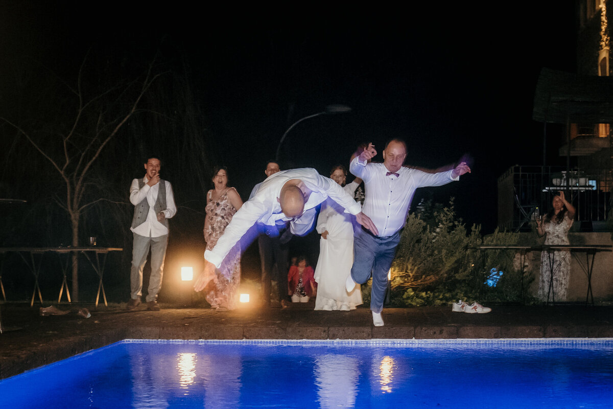 Wedding party moment as guests jump fully clothed in the pool.
