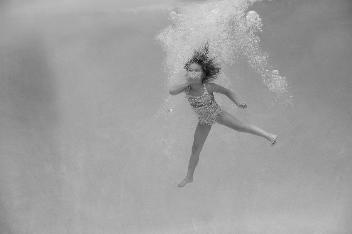 black and white photo of young girl after jumping in water