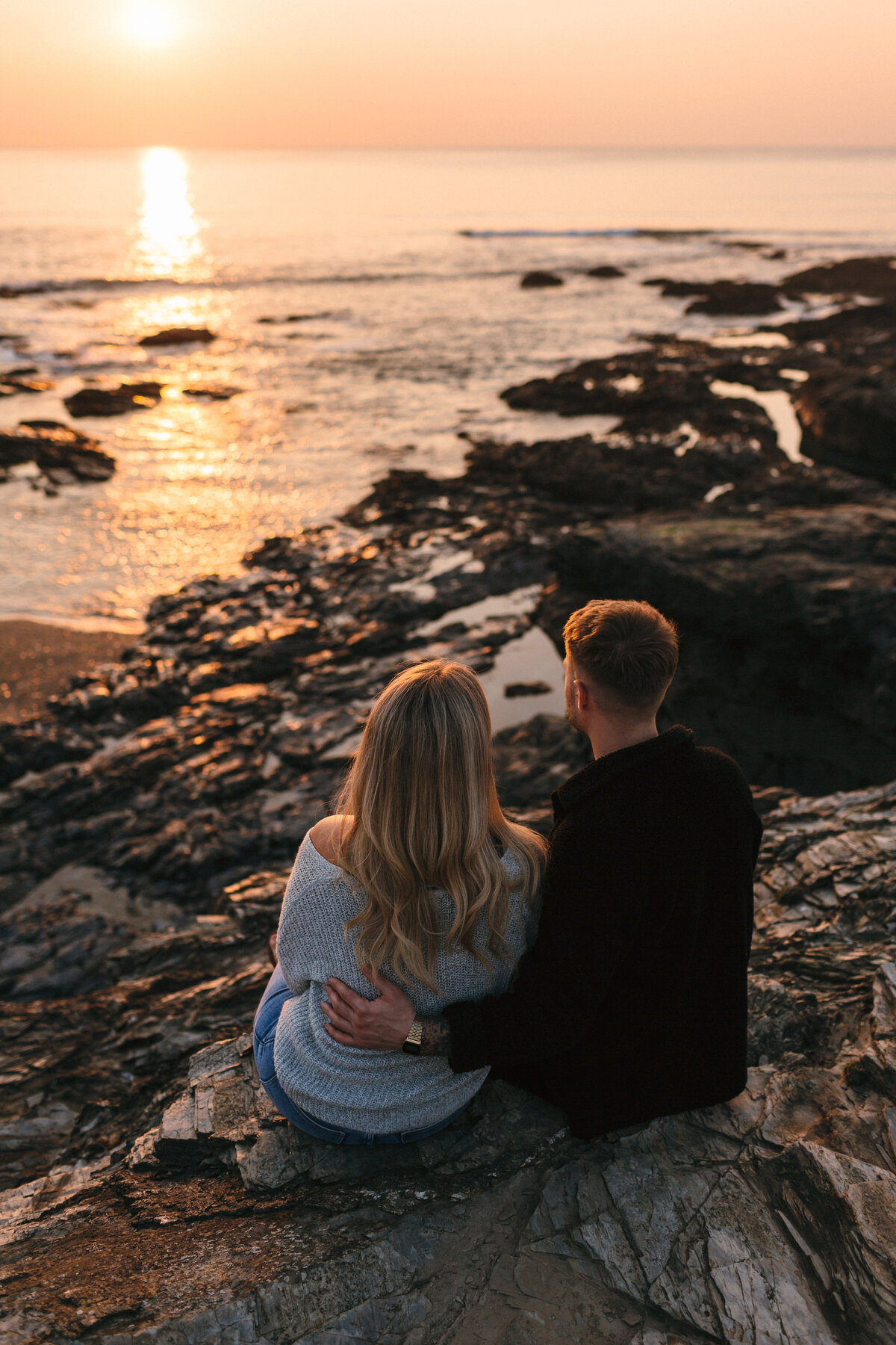 Conrish Coast_Couple watches hazy peach sunset
