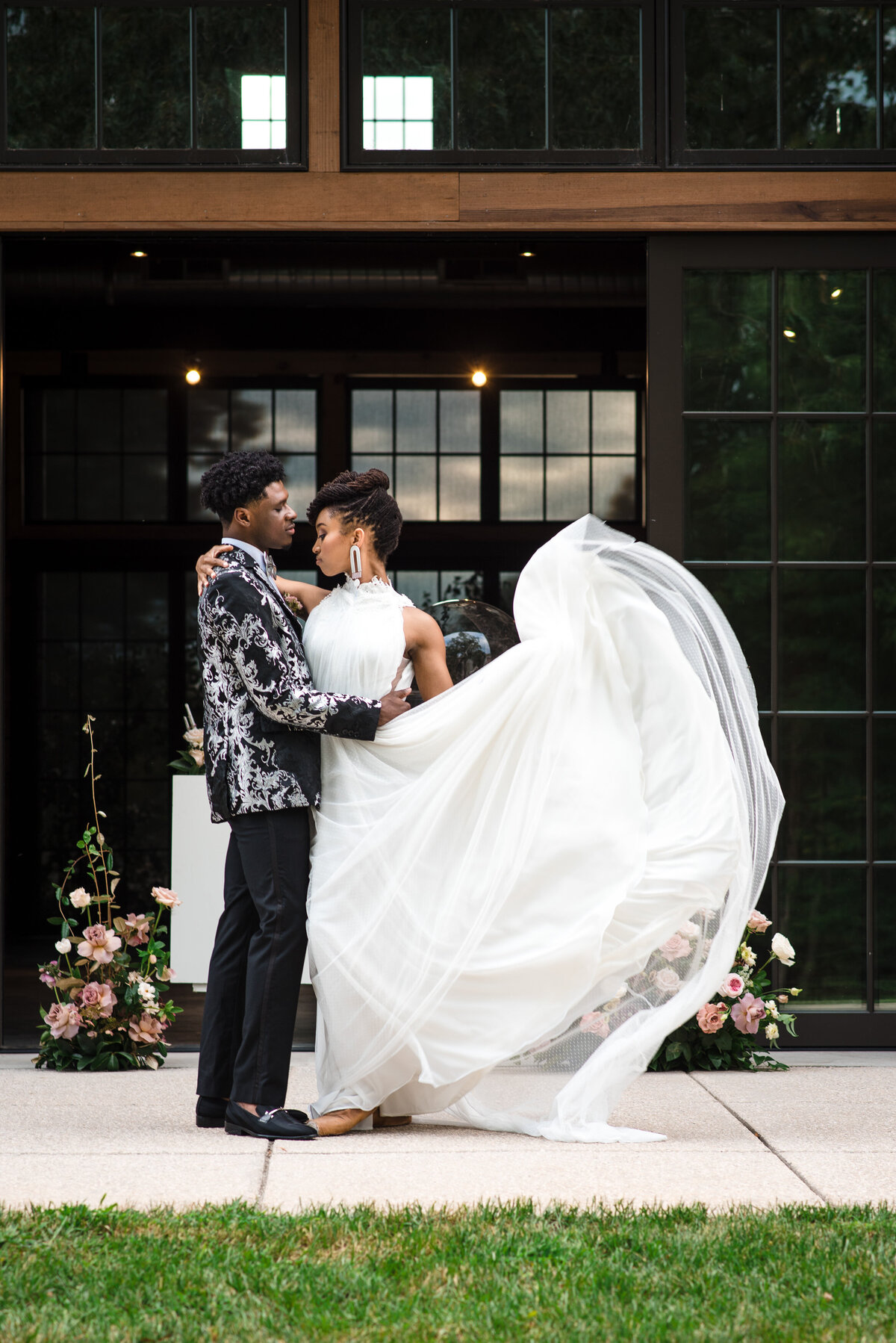 Professional Black bride and groom dancing in front of the doors of North Corner Haven by Charlotte wedding photographer DeLong Photography