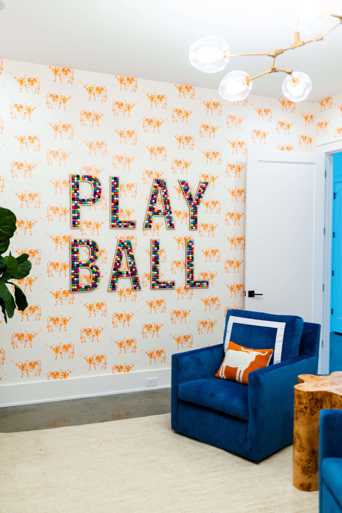 oyster creek studios building belt new build play ball mural on cow wallpaper with blue chair and orange cow pillow