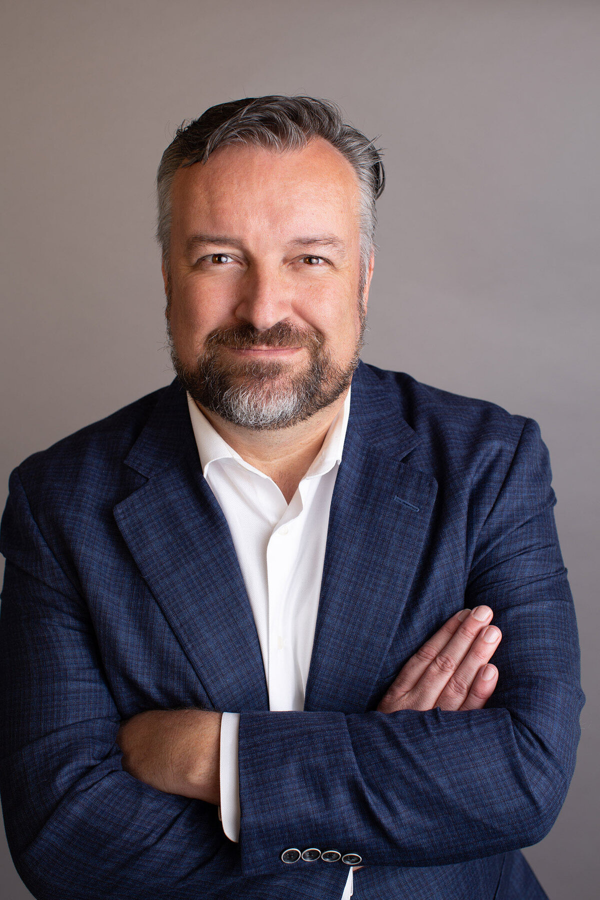 headshot of a male wearing a navy blue jacket and a white shirt