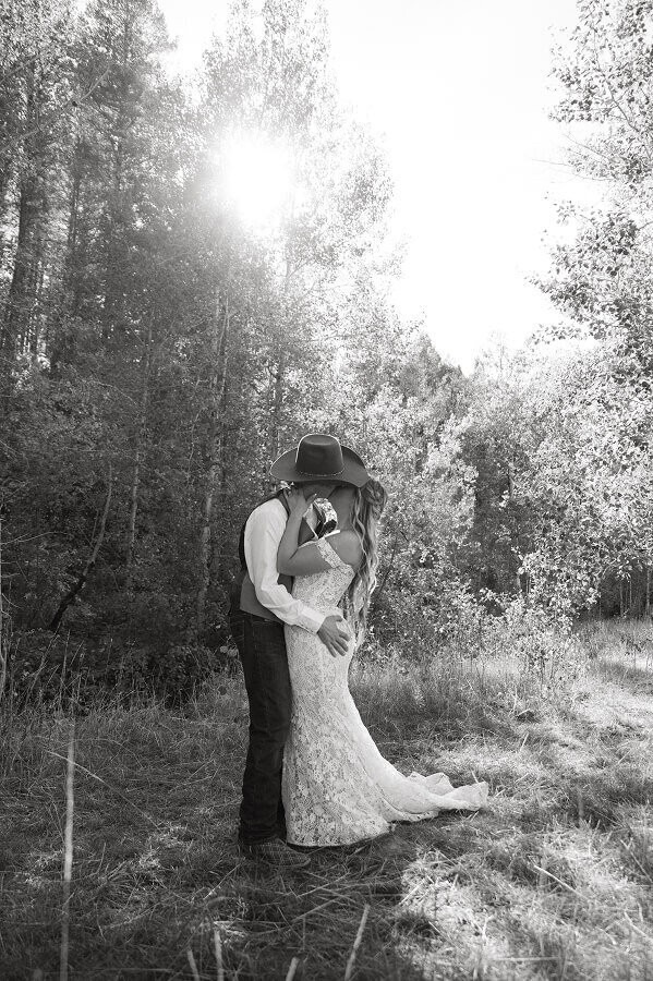 A photo of a bride and groom kissing after their elopement somewhere in the trees in Swan Valley, ID.