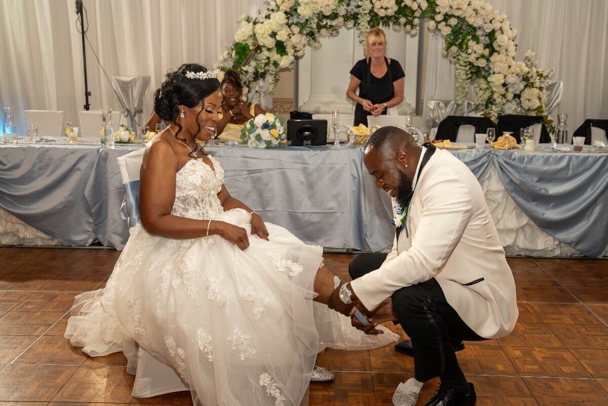 groom-removing-bride-garter-during-reception