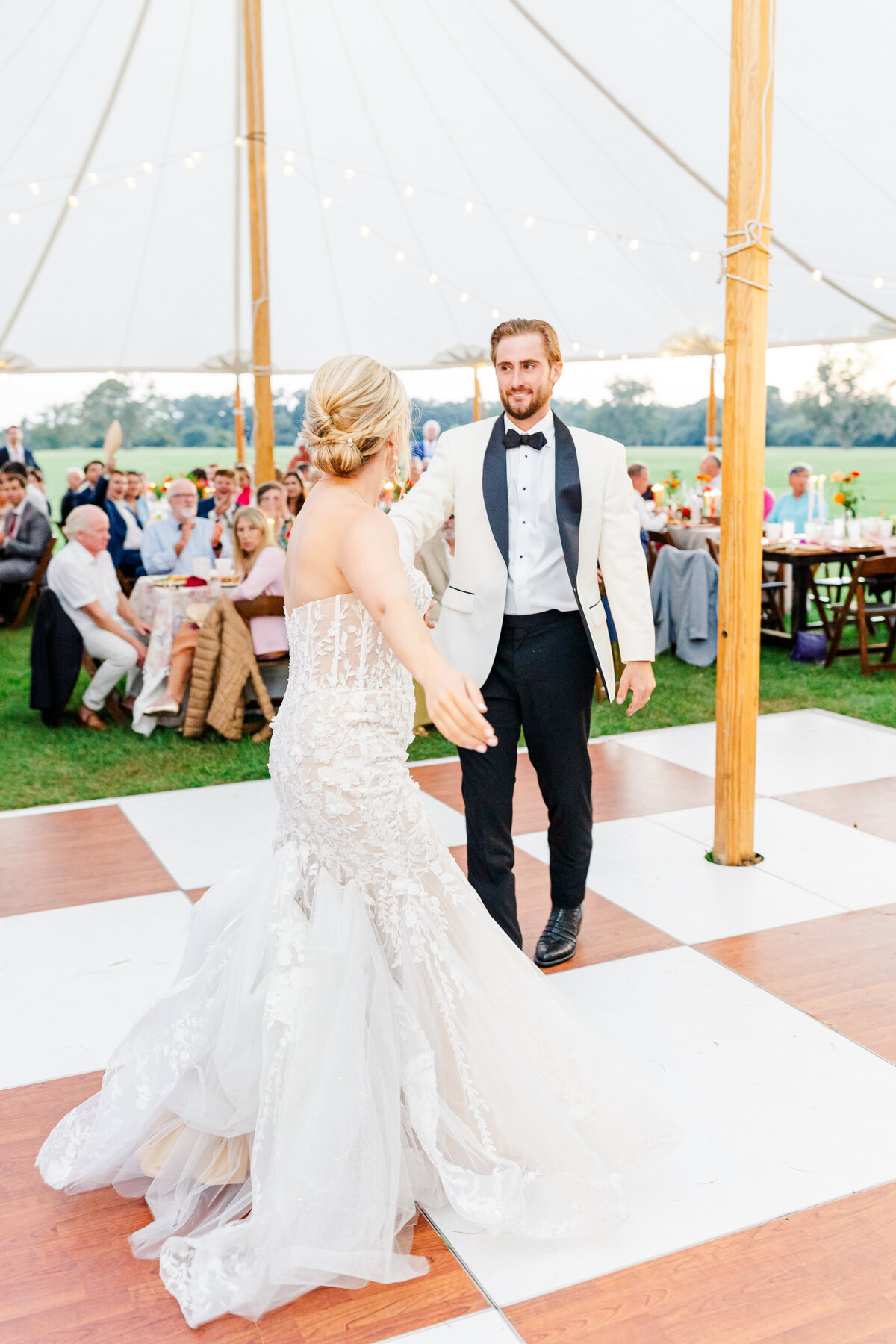 Groom spinning bride on dance floor at their agapae oaks wedding