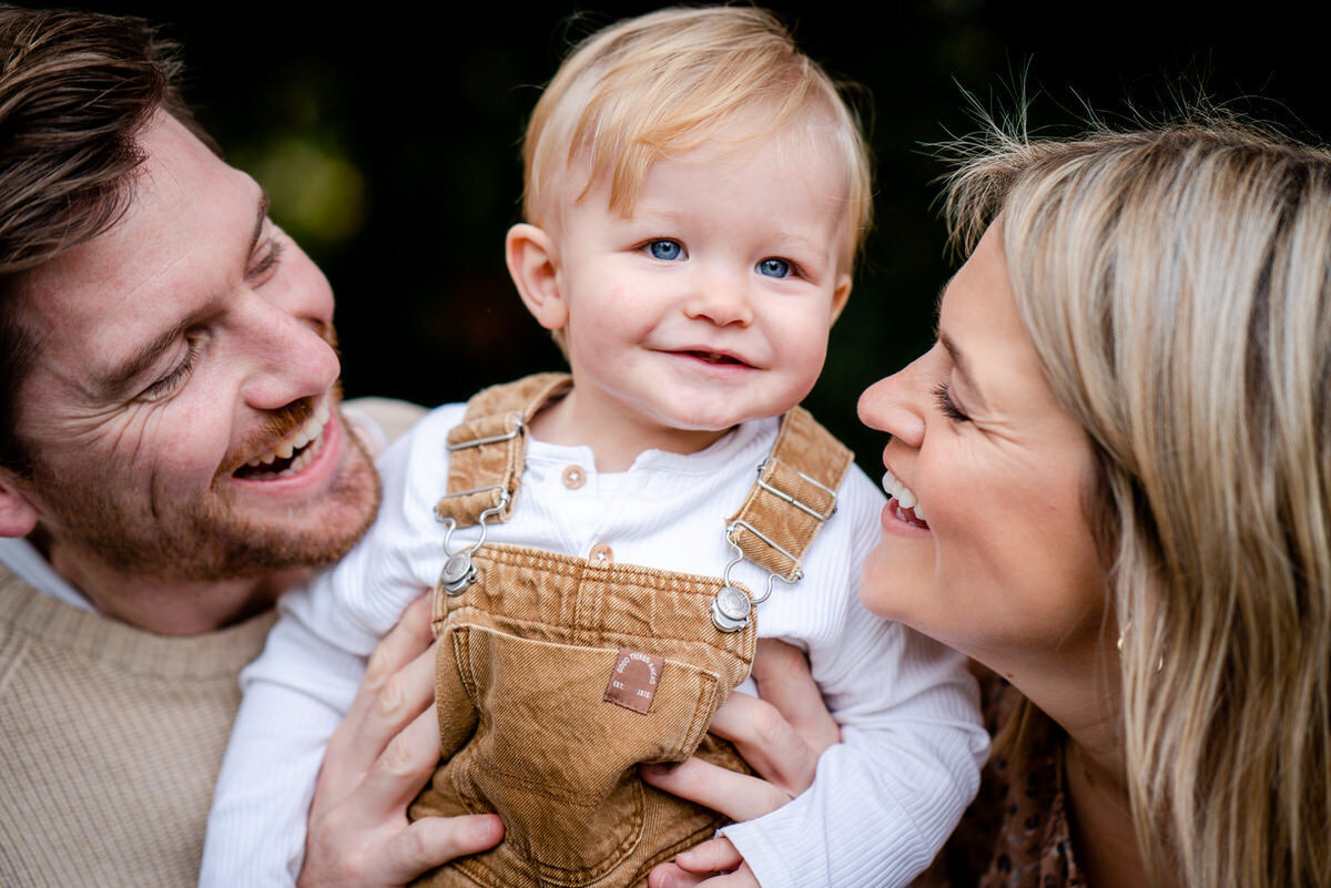 parents stare into the eyes of their young son
