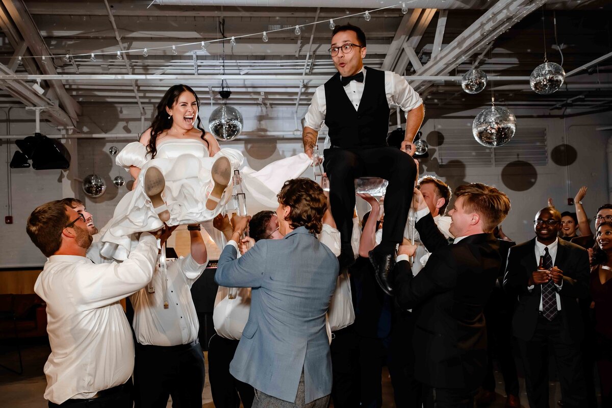 Bride and groom are lifted up during the Hora at Sarabande in Chicago.