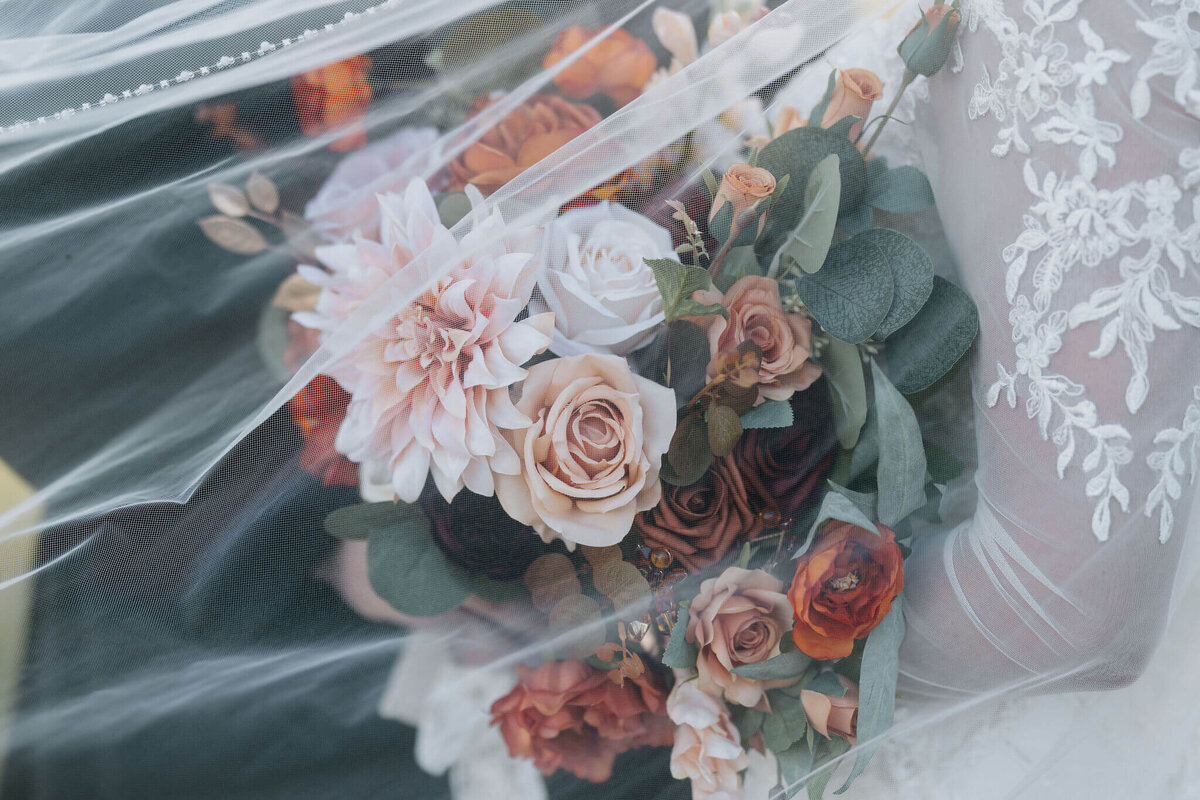 fall bridal bouquet in bride's hands on wedding day