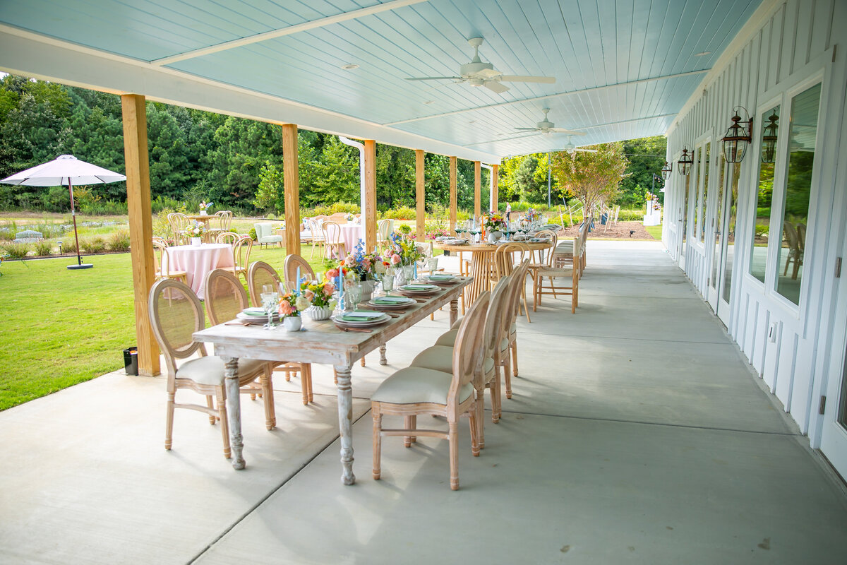 Veranda and blue ceiling with farm table, blue candles and flower centerpieces