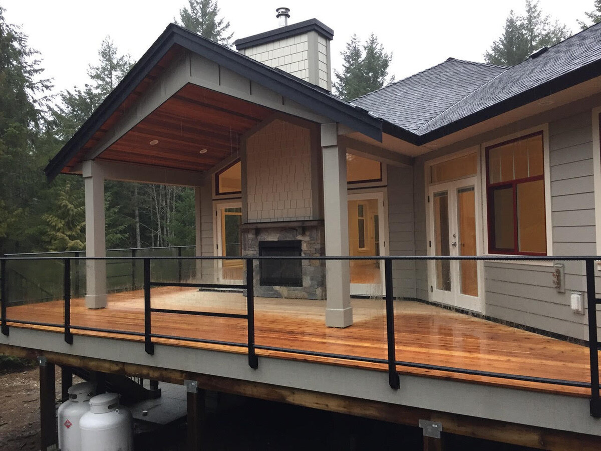 Modern craftsman home exterior design with covered patio and outdoor fireplace.