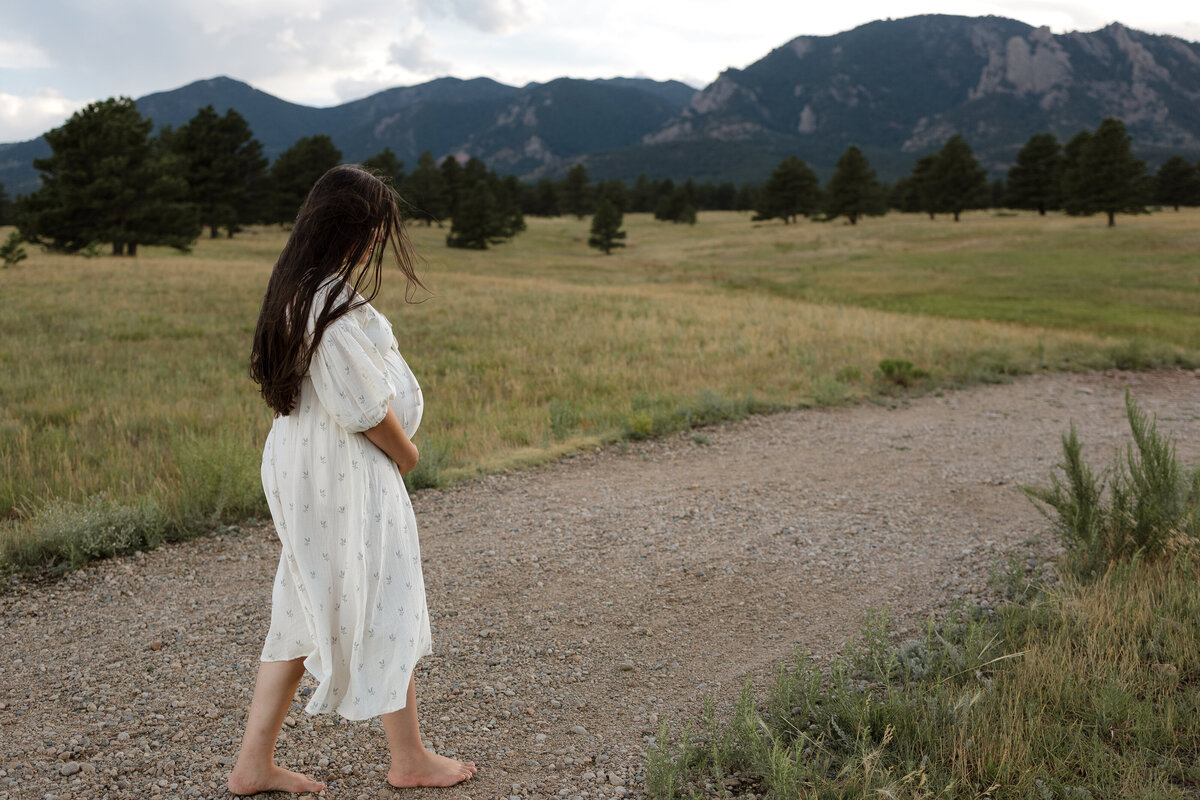 Expectant mom walking barefoot on path during maternity session in Boulder Colorado during maternity session with Alexis Adkins Photography