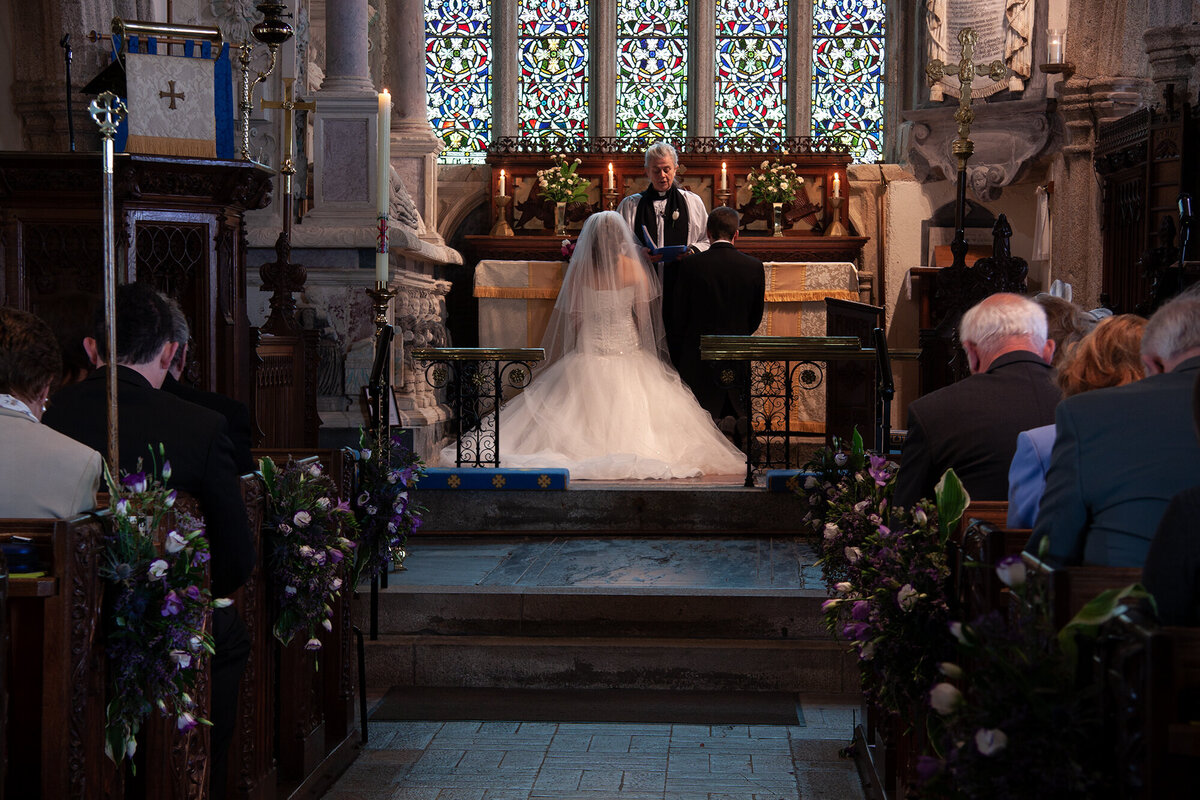 pro-story-photography_bride-and-groom-knealling-at-the-altar_wembury-church_wembury-plymouth_devon