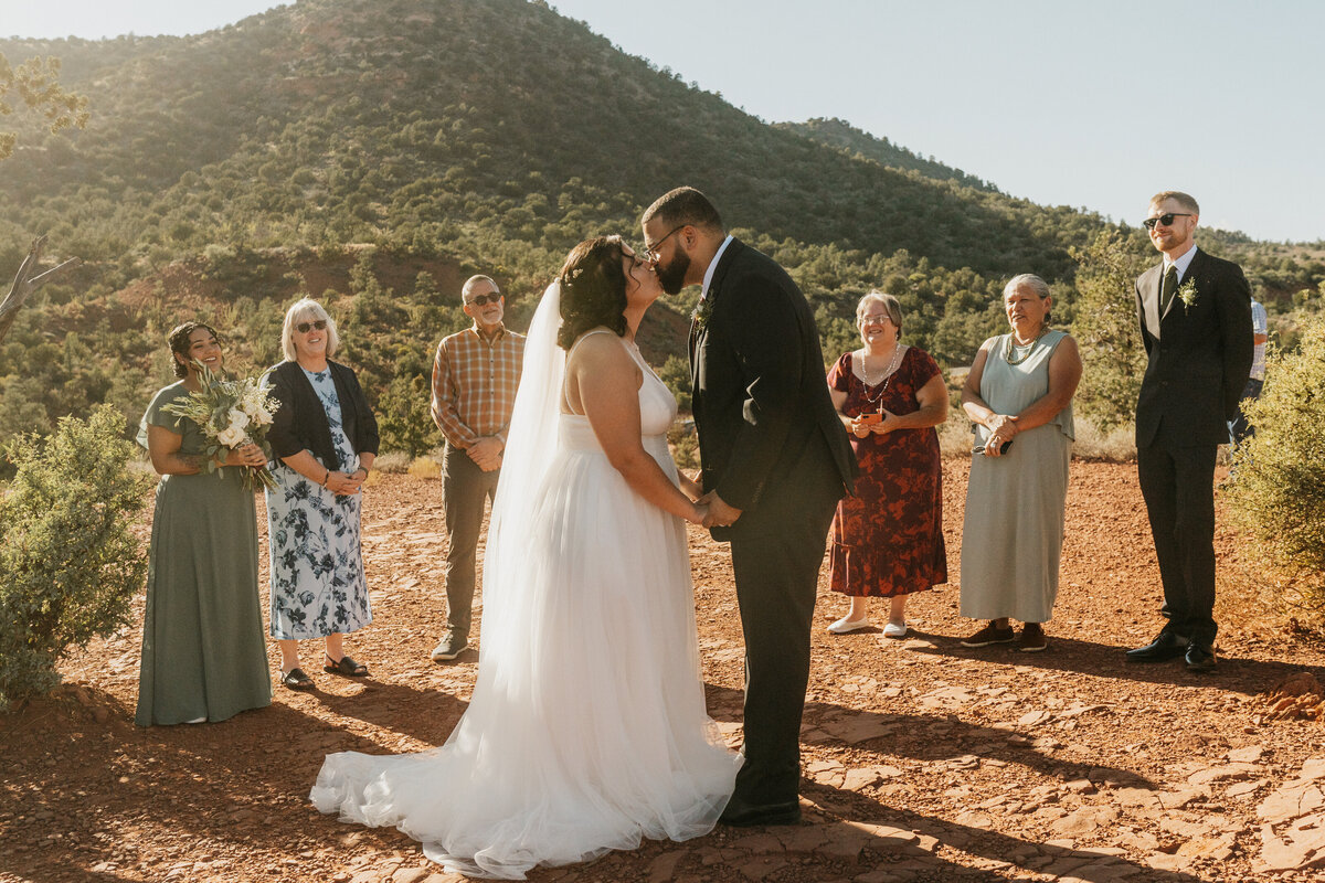 A newlywed couple during their first kiss in the desert 