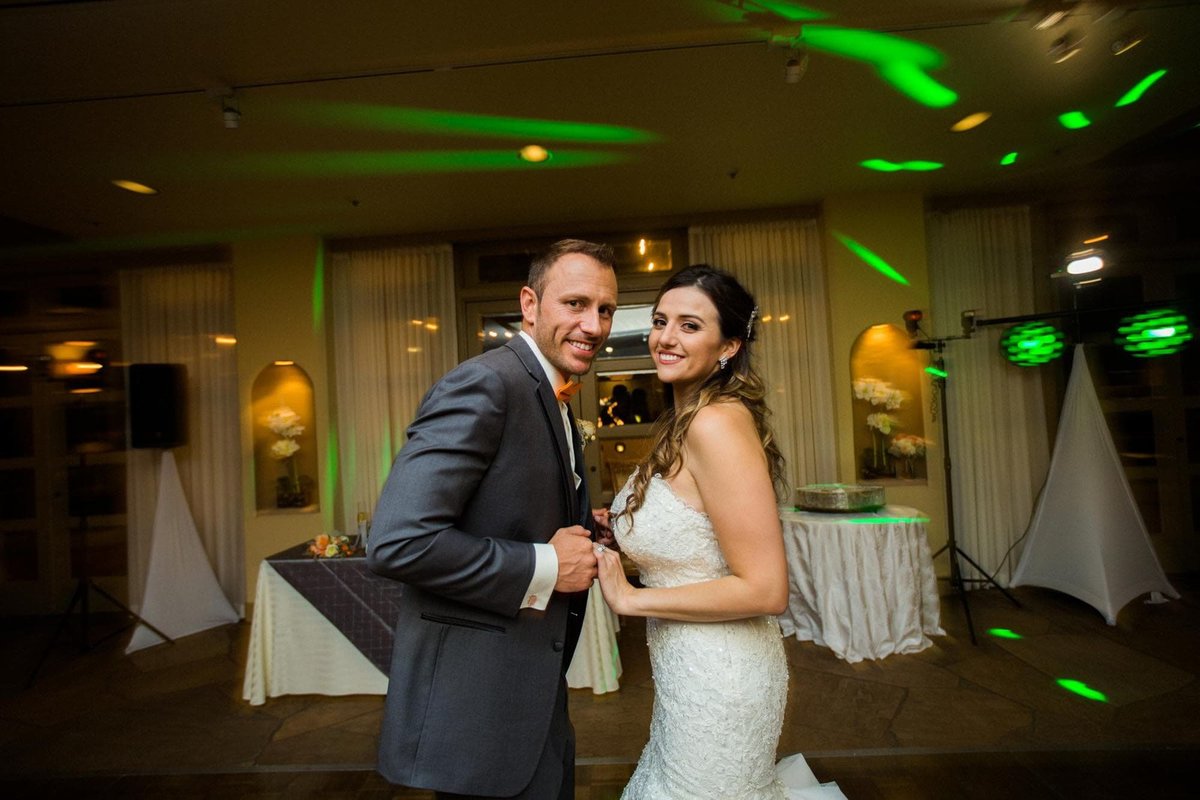 Newly married couple smile for the camera on the dancefloor