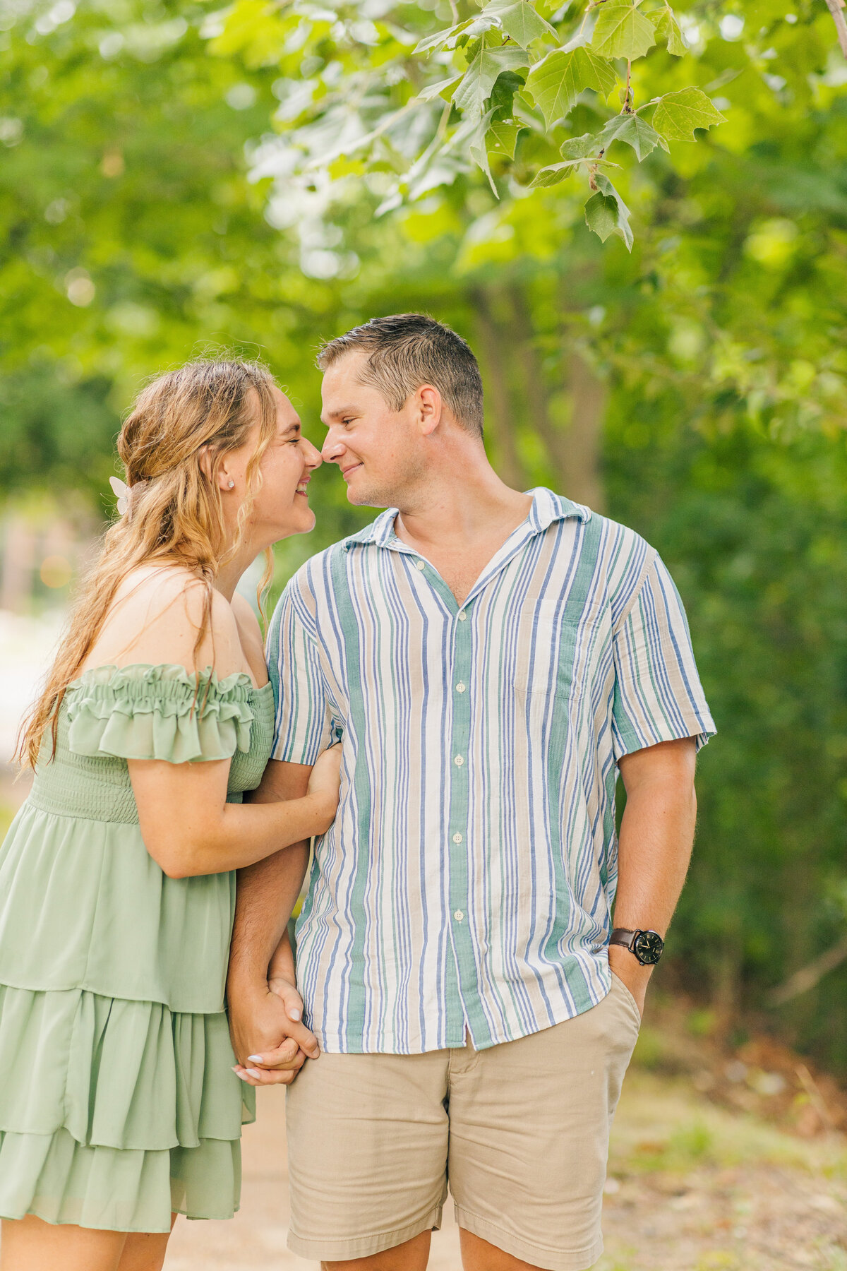 man and woman dressed in coordinating clothing woman leaned into man touching noses and smiling