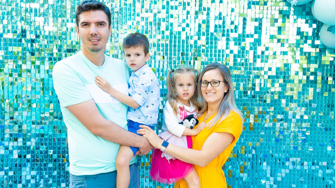 family in front of a shimmer wwall