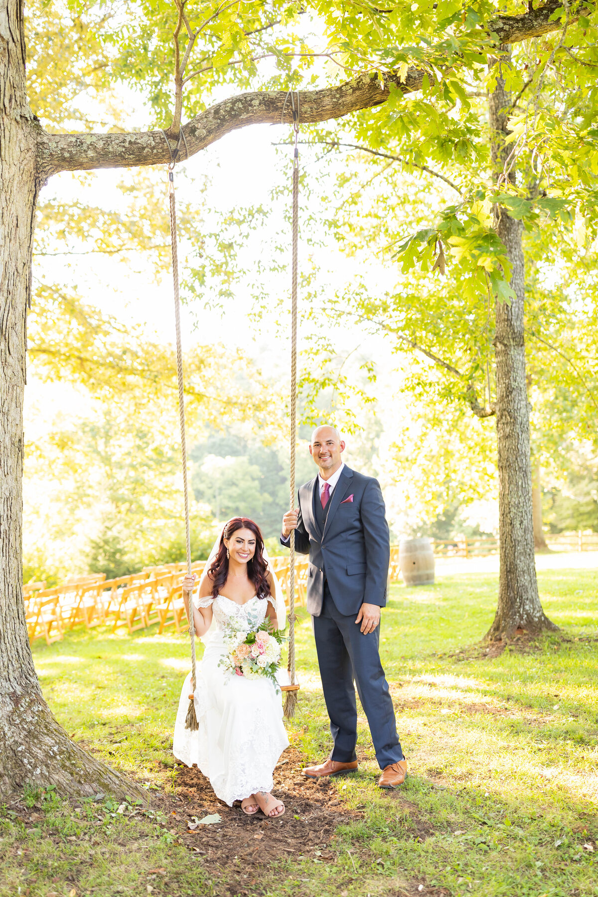 Bride poses on swing alongside groom by Tiffany McFalls.
