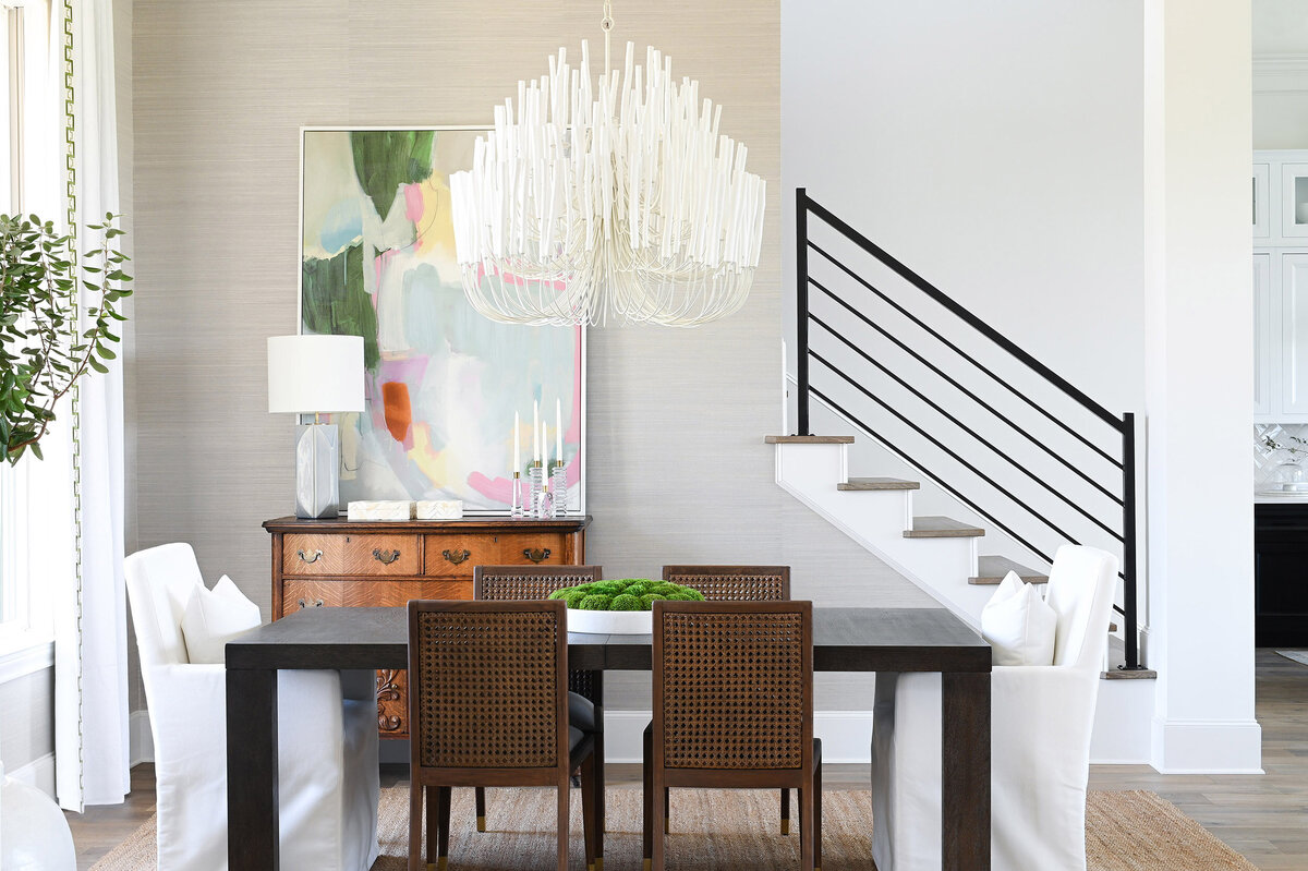 Modern dining room with large chandelier and abstract artwork on wall