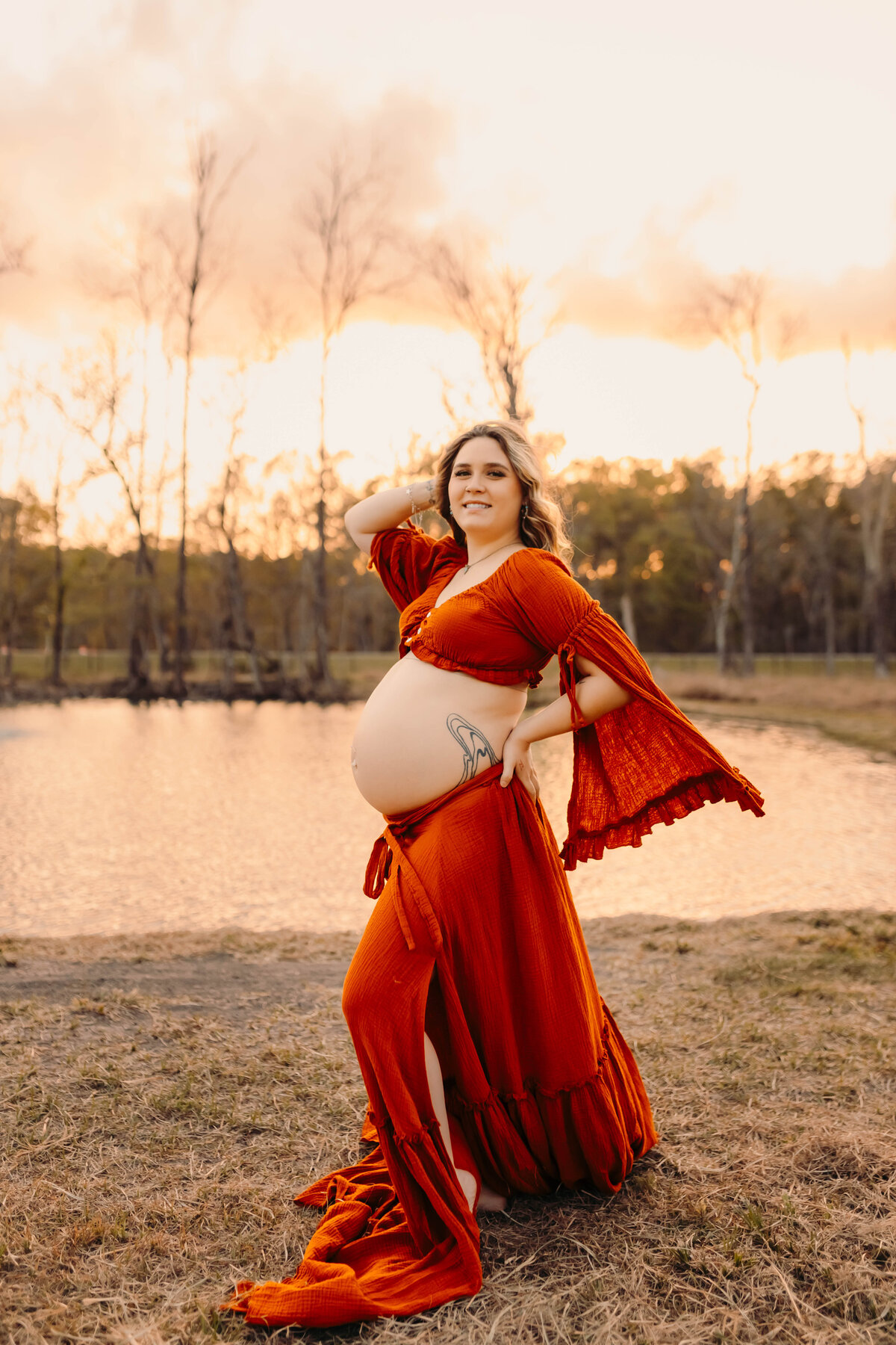 Cleveland TX maternity portraits—pregnant woman in burnt orange gown near water