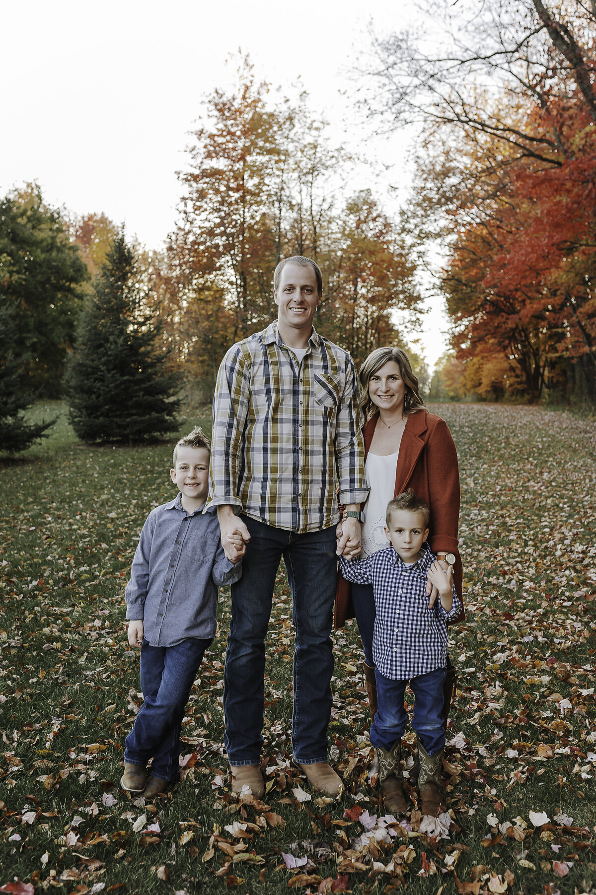 Verona B Photography captures a beautiful fall family photo of a mom, dad, and their two boys at Silver Creek metro Park in Norton, OH. The fall leaves were really at peak color and the sun was perfect for this family photo session near Akron.