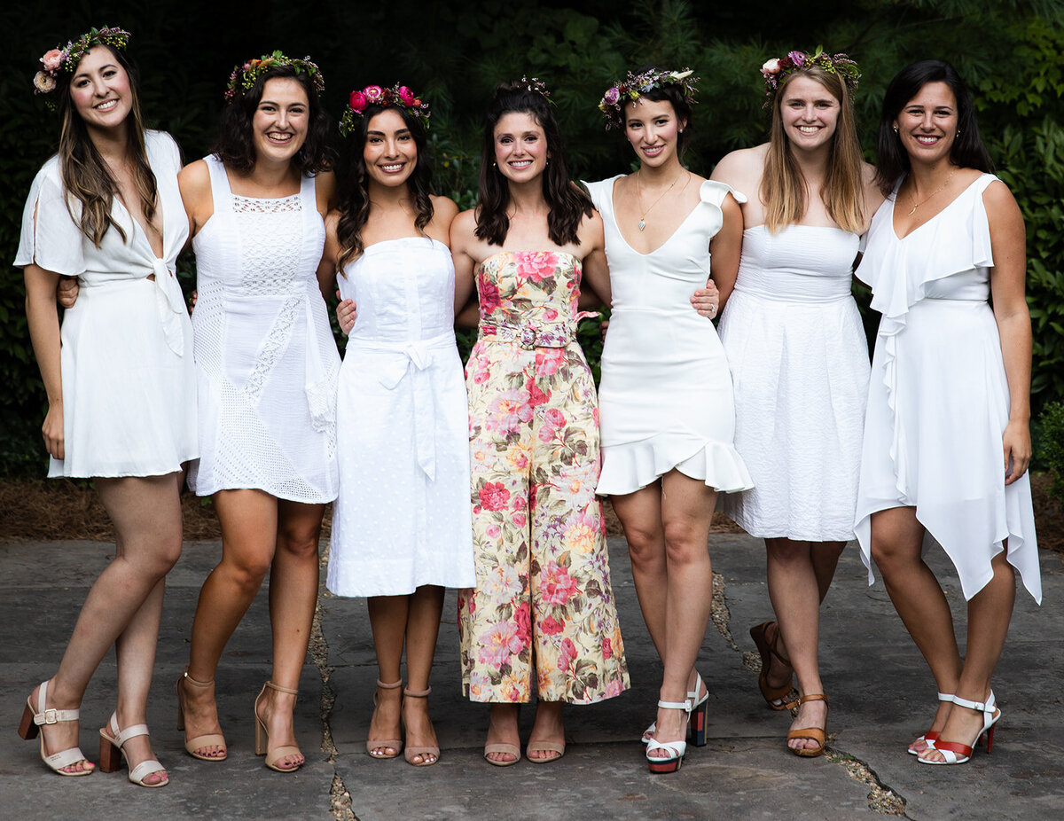 White linen welcome dinner with flower crown for every guest. Wildflower crown booth by Rosemary & Finch, RT Lodge and Nashville luxury wedding florist.