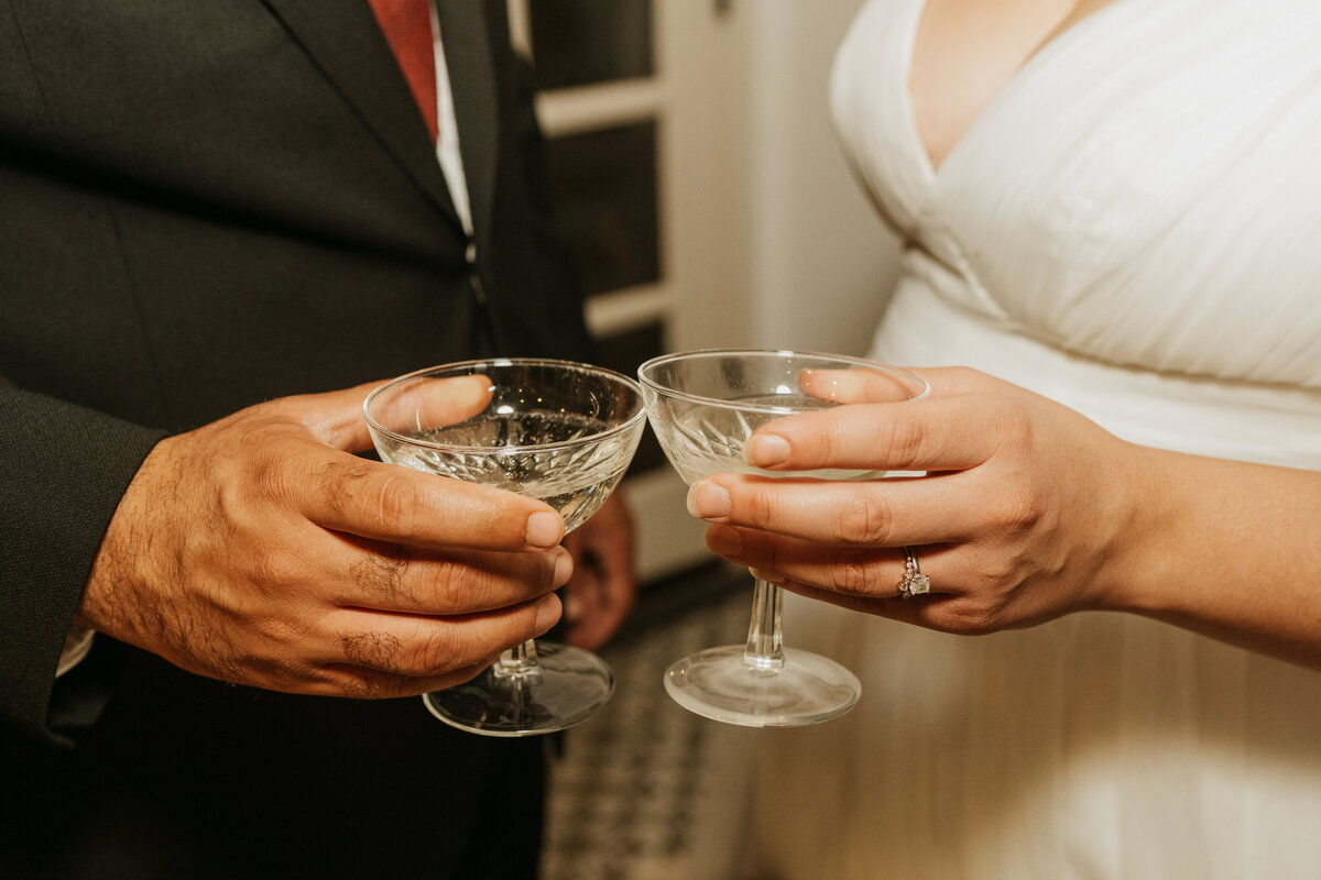 A close up of two people toasting glasses 
