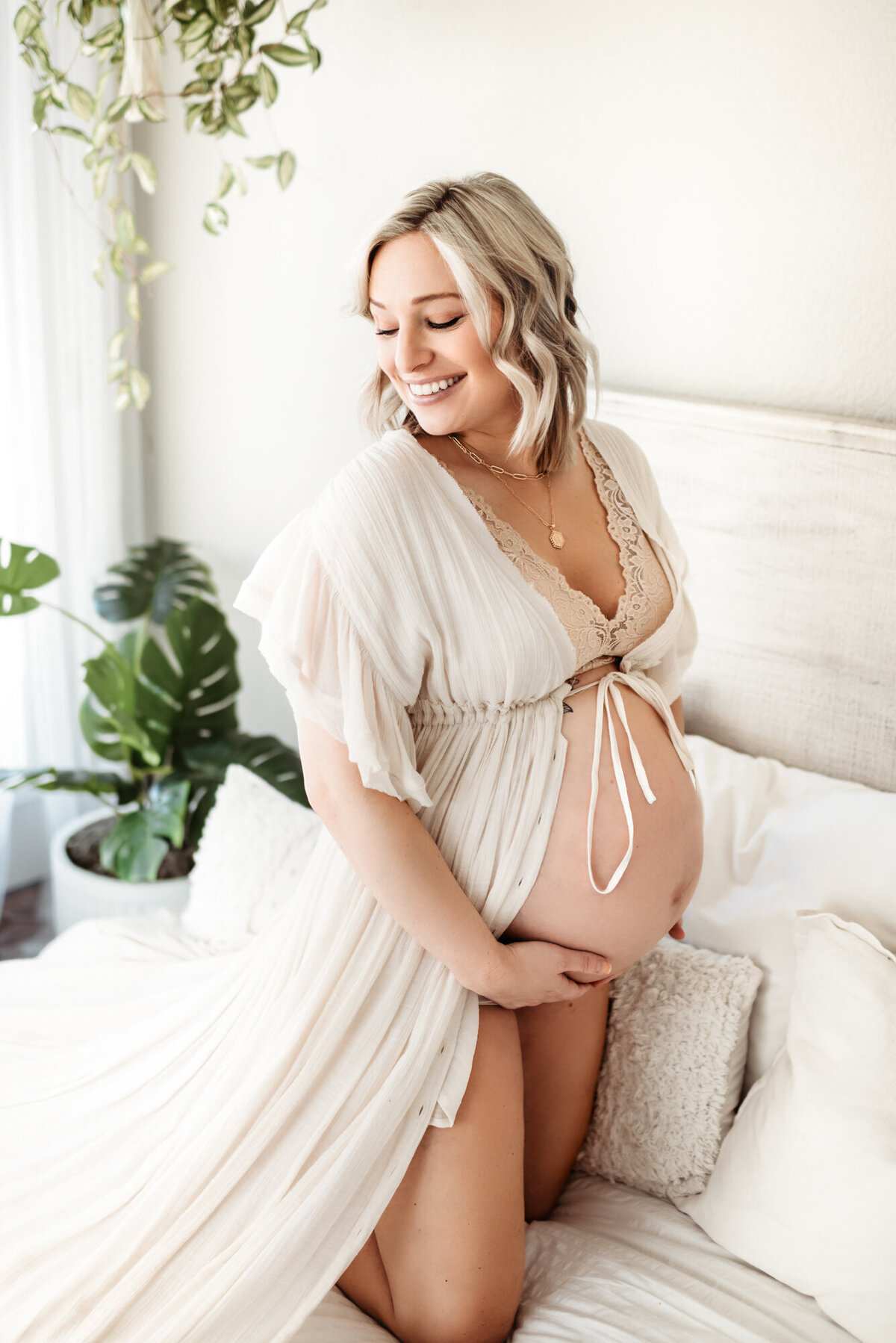 pregnant woman with bare belly in maternity sunroom