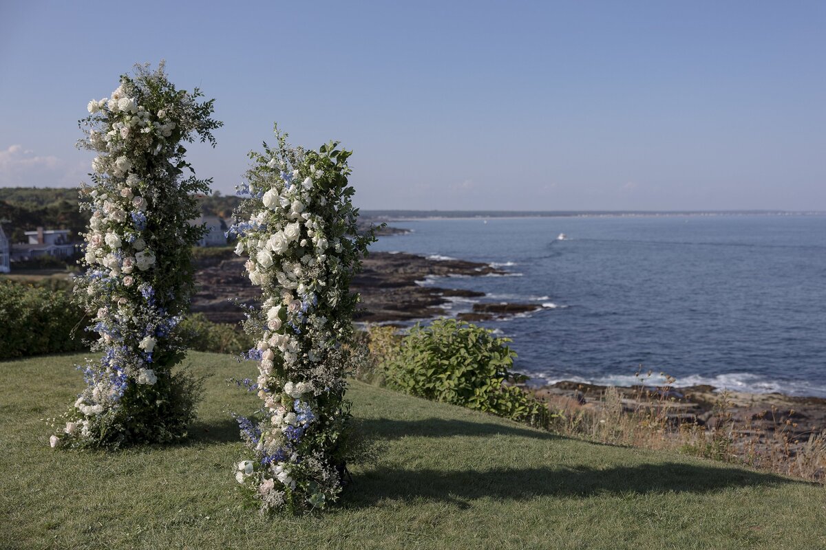 Wedding ceremony floral arch overlooking Maine coast at Cliff House Maine.
