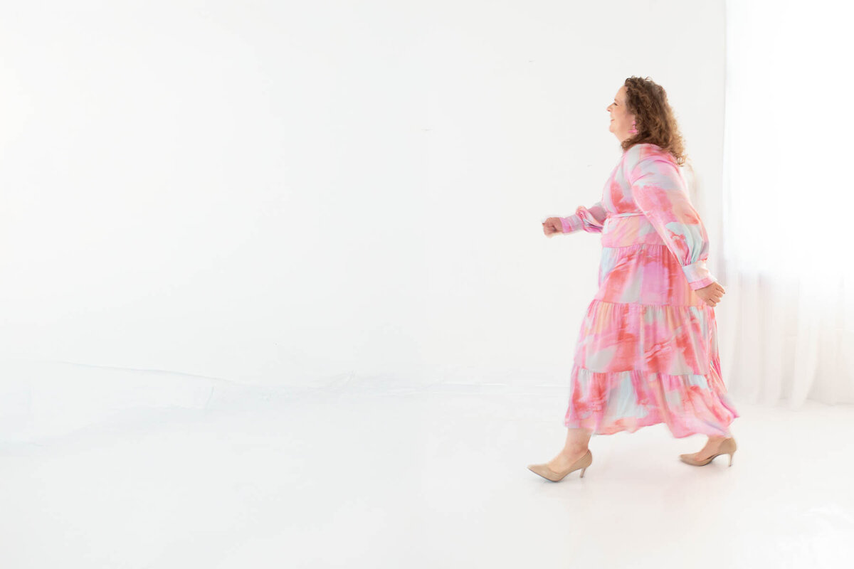 Profile shot of an editorial wedding photographer walking with intention, looking away from the camera.