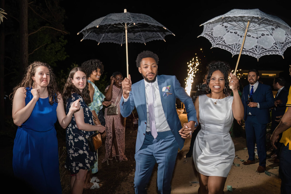 Festive wedding second line parade with the groom leading the celebration, embracing New Orleans-style tradition.