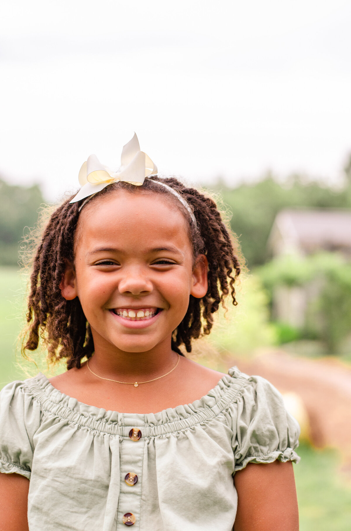 a little girl smiles in a field in amsterdam