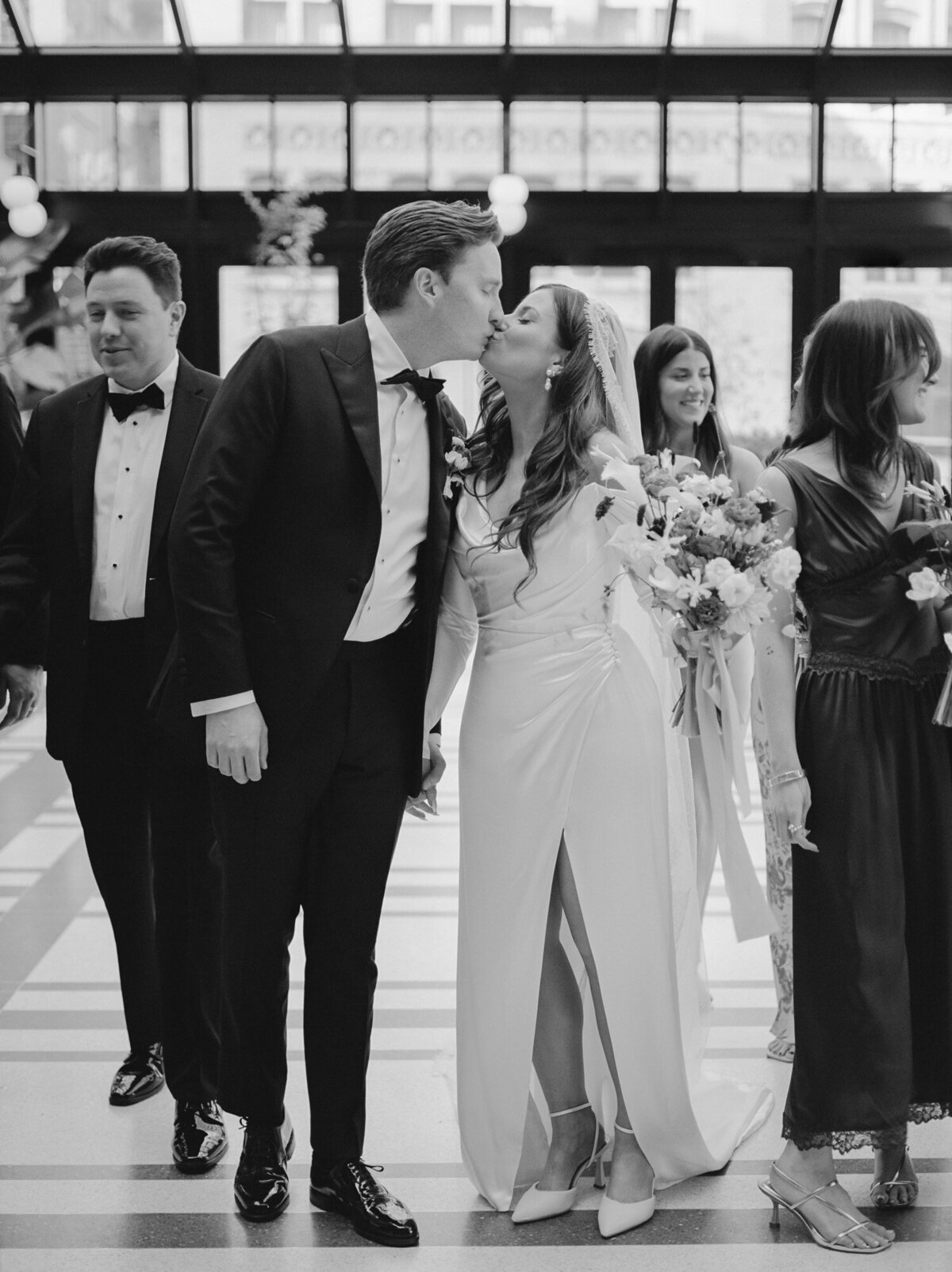 a bride and groom walk with their wedding party at Shinola Hotel birdy room, Detroit, Michigan