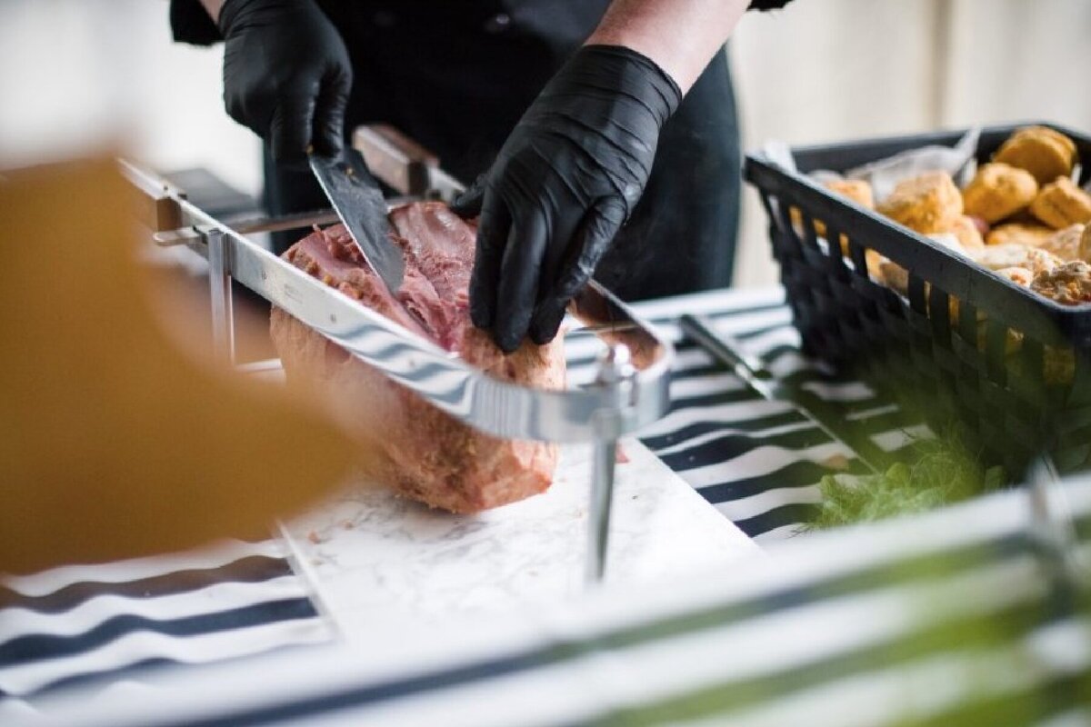 chef carving a southern baked ham with biscuits at Willowbrook wedding venue
