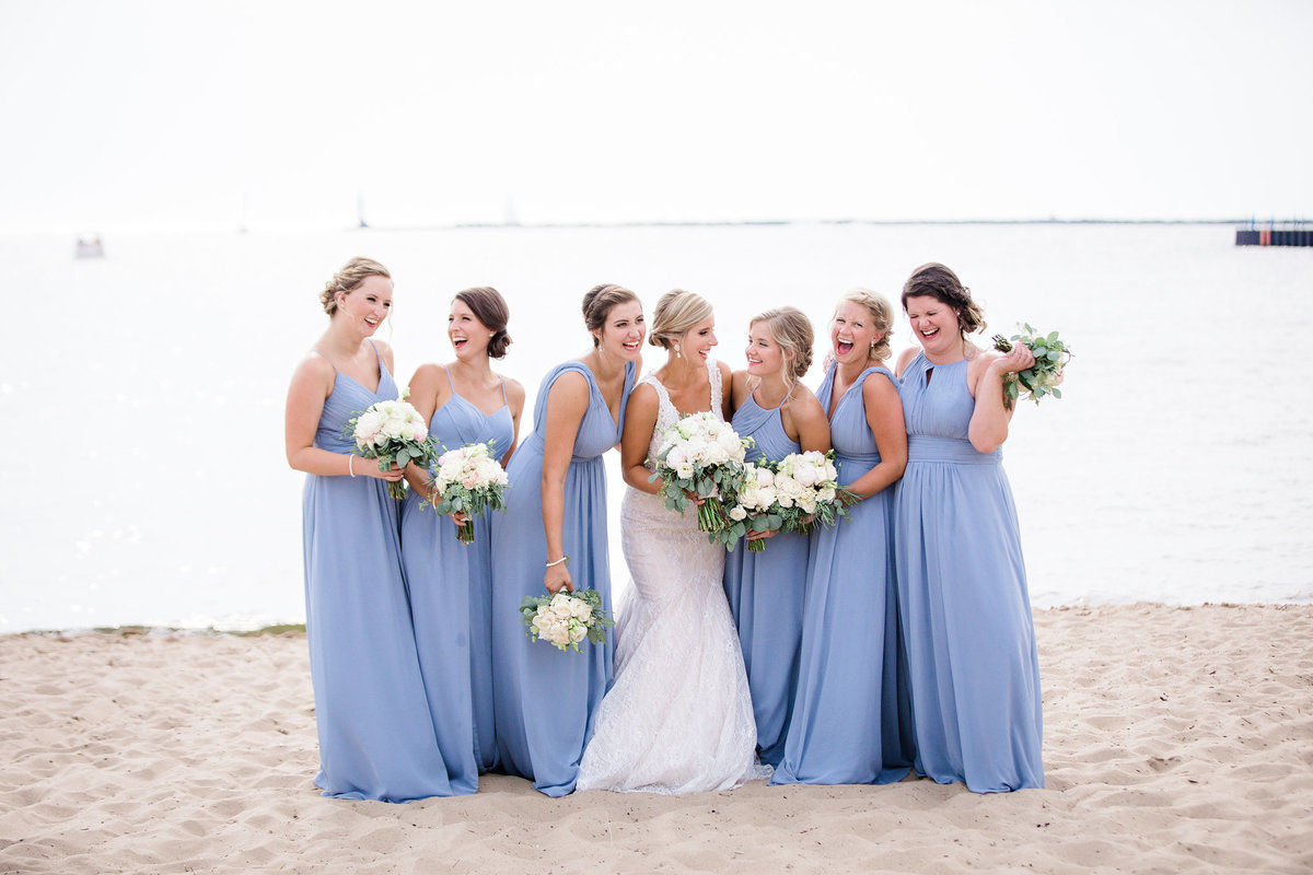Beautiful bridesmaids laugh on the beach of Lake Michigan.