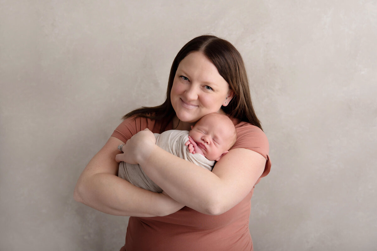 mom holding newborn baby boy for his Burlington, Ontario newborn photography photos.