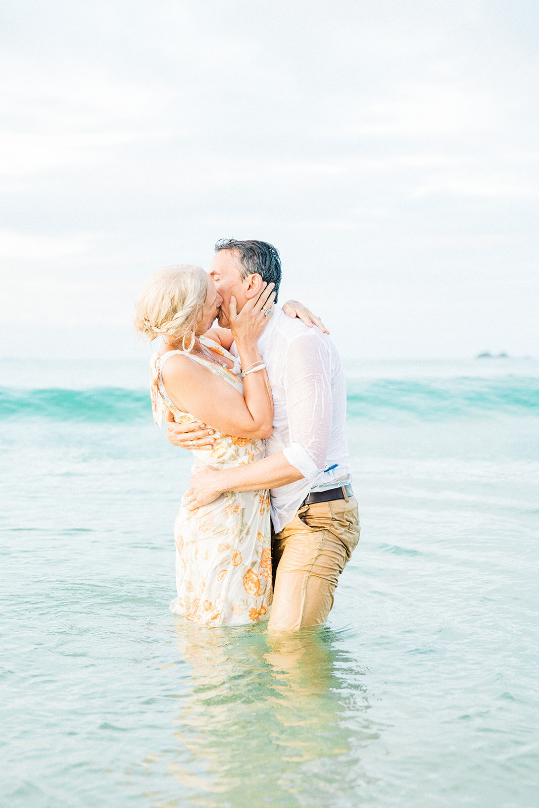husband and wife kissing in ocean