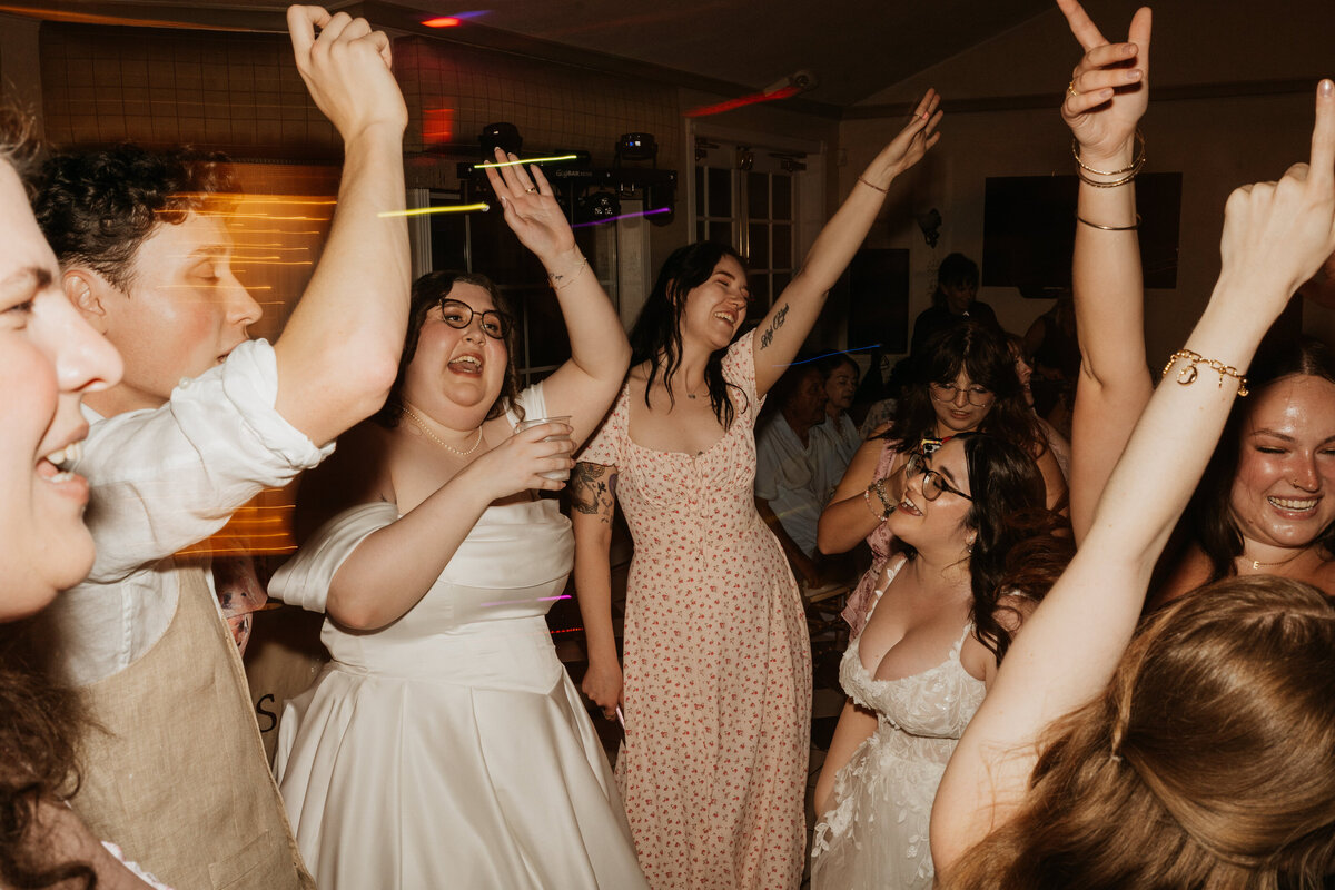 A newlywed person dancing at their reception with their guests 