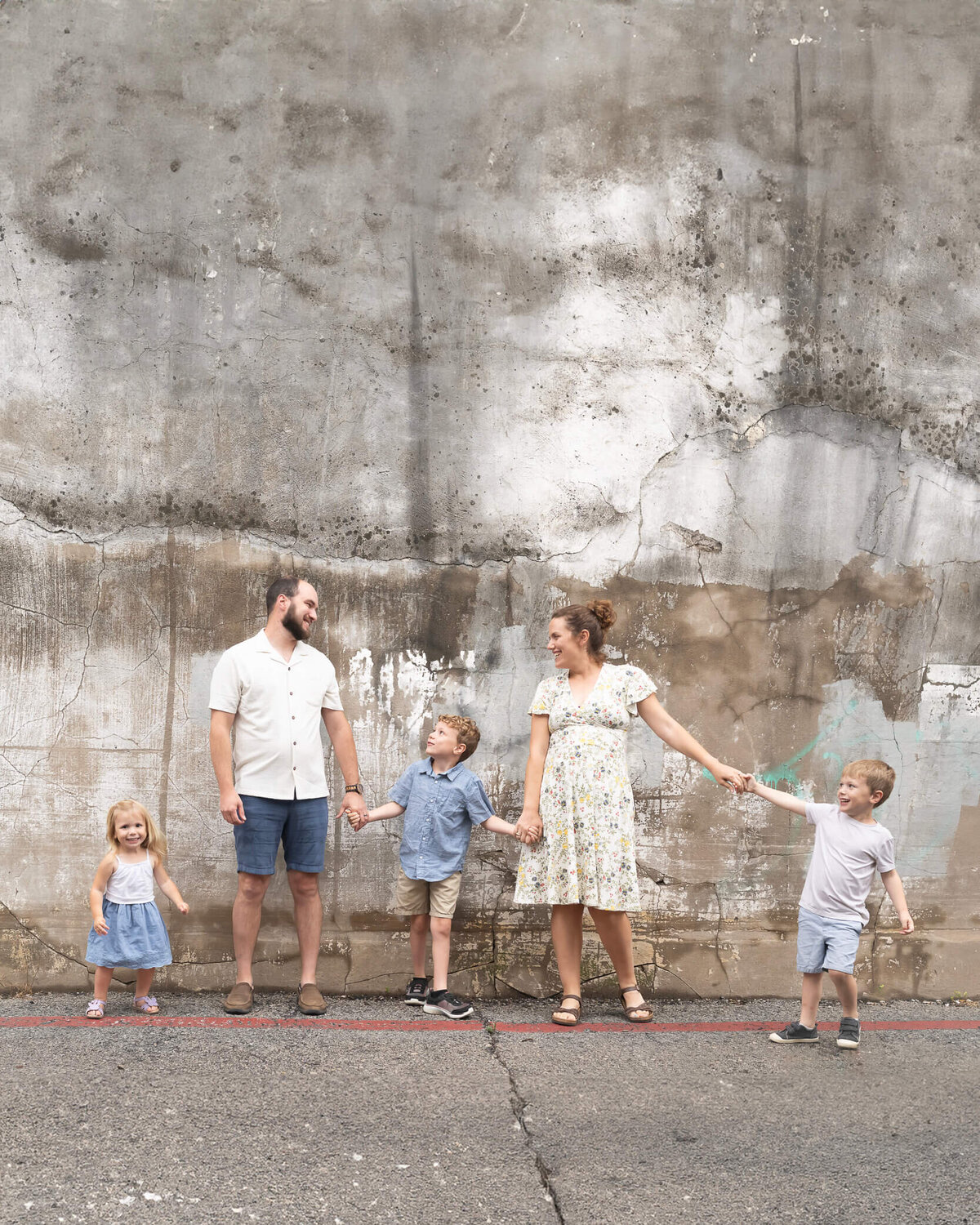 cutest family holding hands in a line, having fun