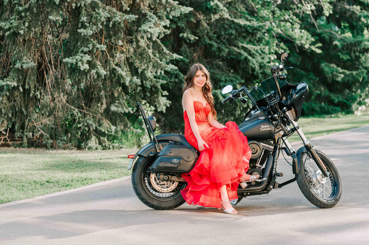 A young woman sitting on a harley motorcycle