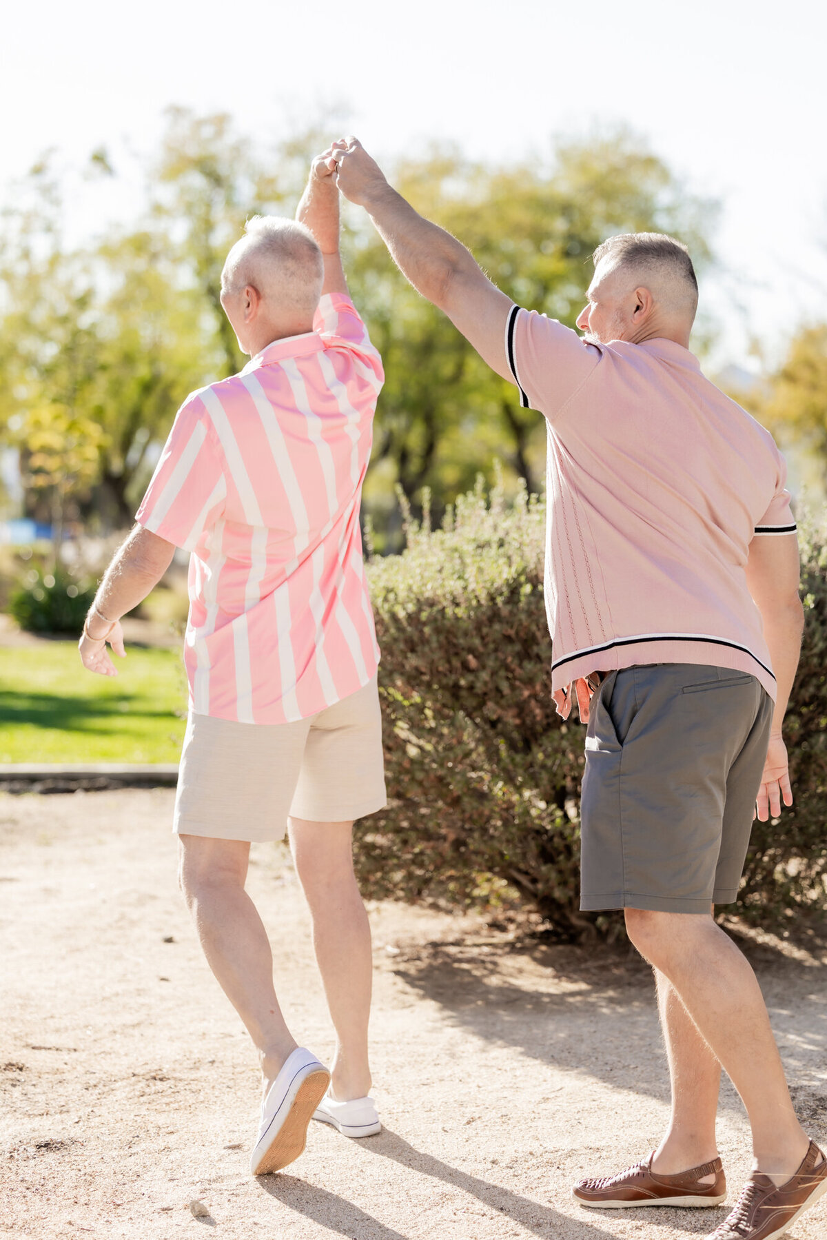 Couple walking along desert path in coordinating outfits, captured in a candid, affectionate moment.