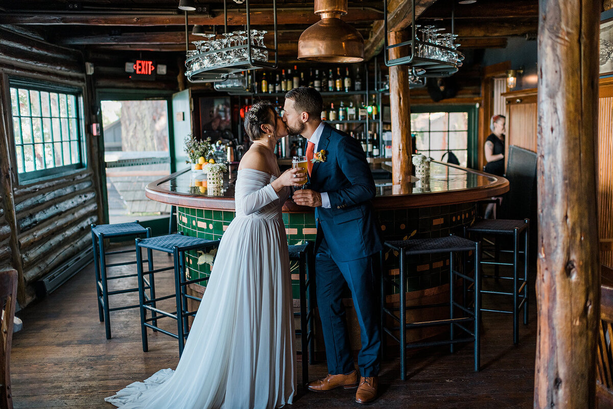 Bride & groom kissing in front of the bar during their intimate wedding at the historic Captain Whidbey Inn!