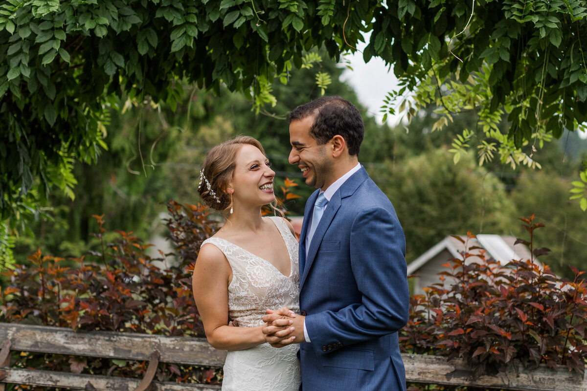 Bride-and-groom-share-a-laugh-after-their-wedding-ceremony-at-Snohomish-wedding-venue-Green-gates-at-Flowing-Lake-photo-by-Joanna-Monger-Photography