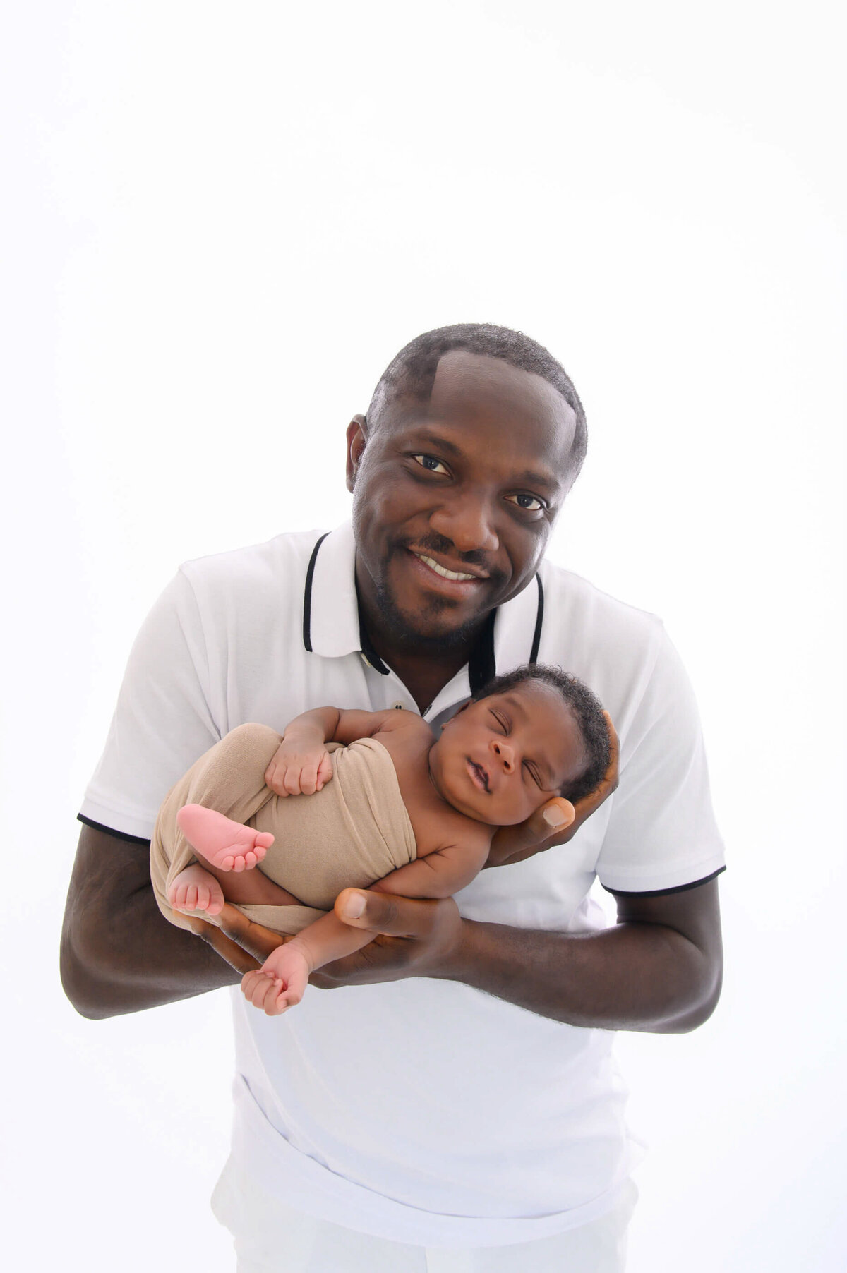 dad holding newborn baby boy for his newborn photography session in Burlington, ON.