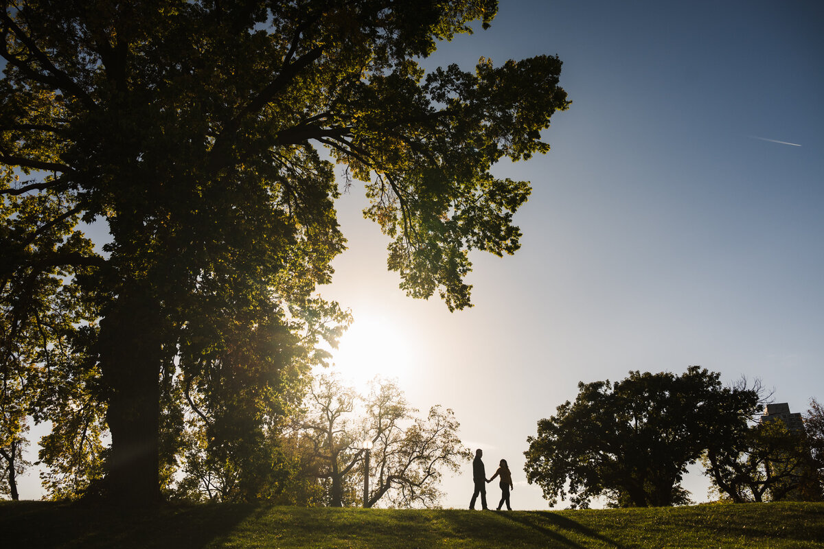 A couple walk together on a hill