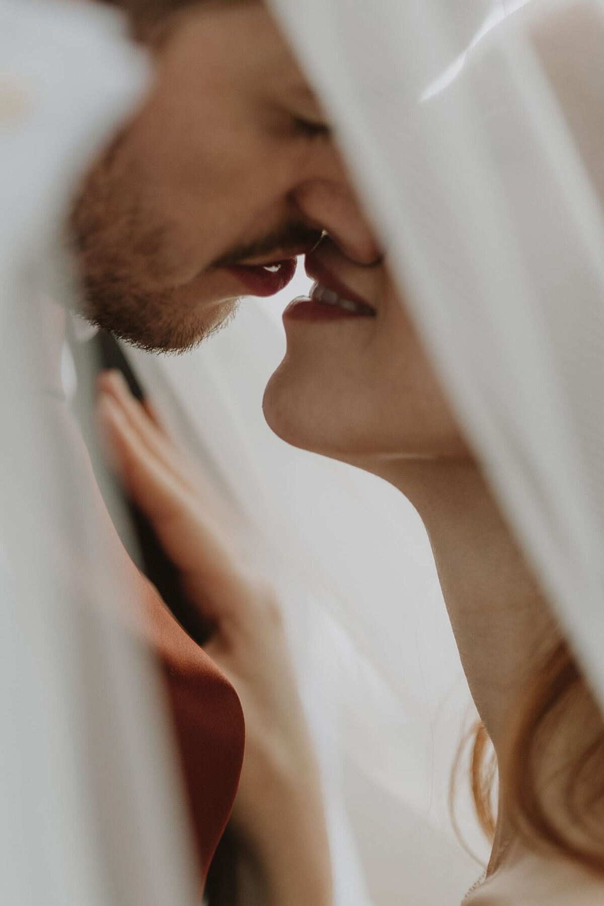 Close up kissing portrait of a bride and groom