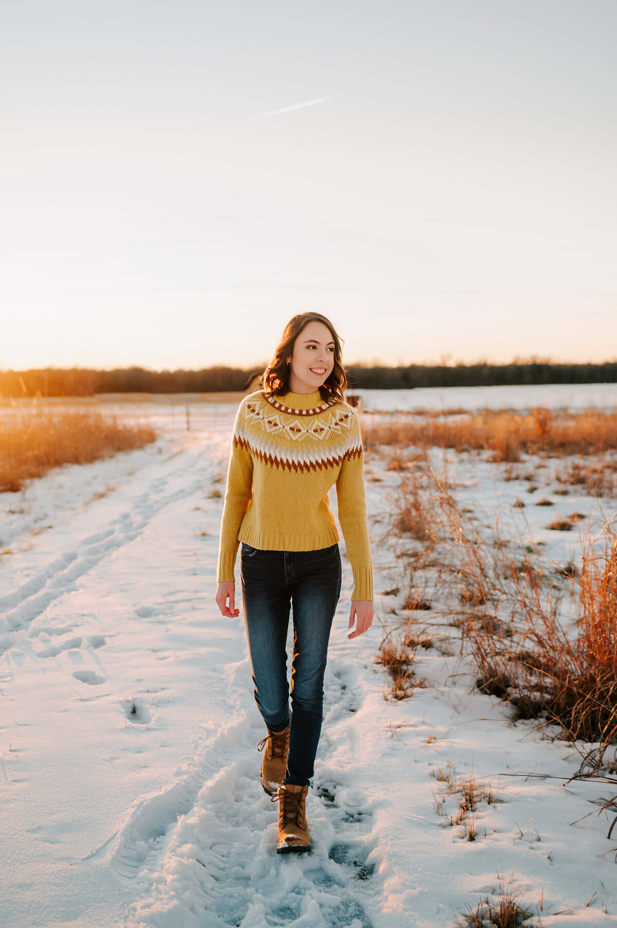teen girl walking in snow laughing enjoying senior pictures in Branson Missouri